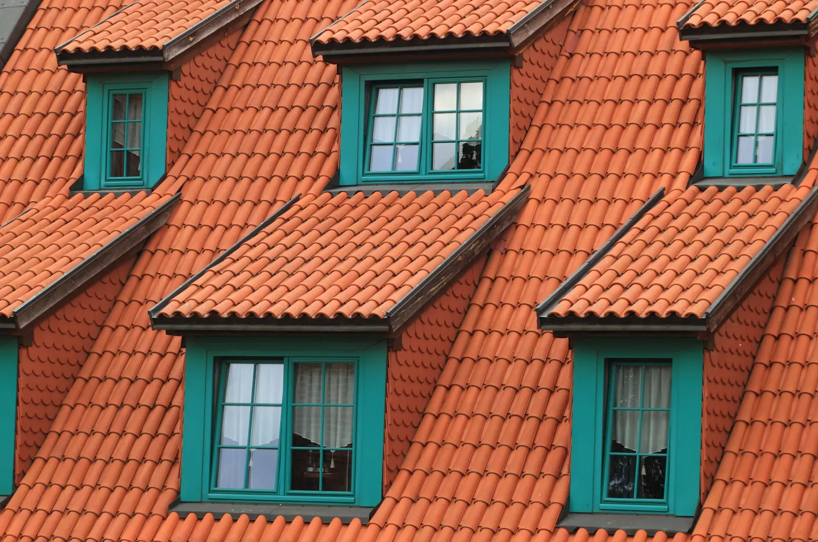 Pannendak met drie dakkapellen met groene kozijnen